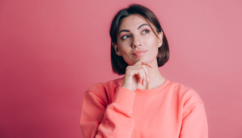 Woman wearing casual sweater on background hand on chin thinking about question, pensive expression. Smiling with thoughtful face