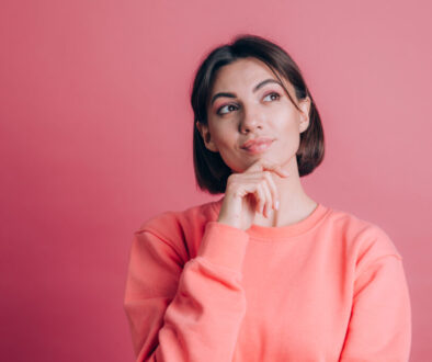 Woman wearing casual sweater on background hand on chin thinking about question, pensive expression. Smiling with thoughtful face