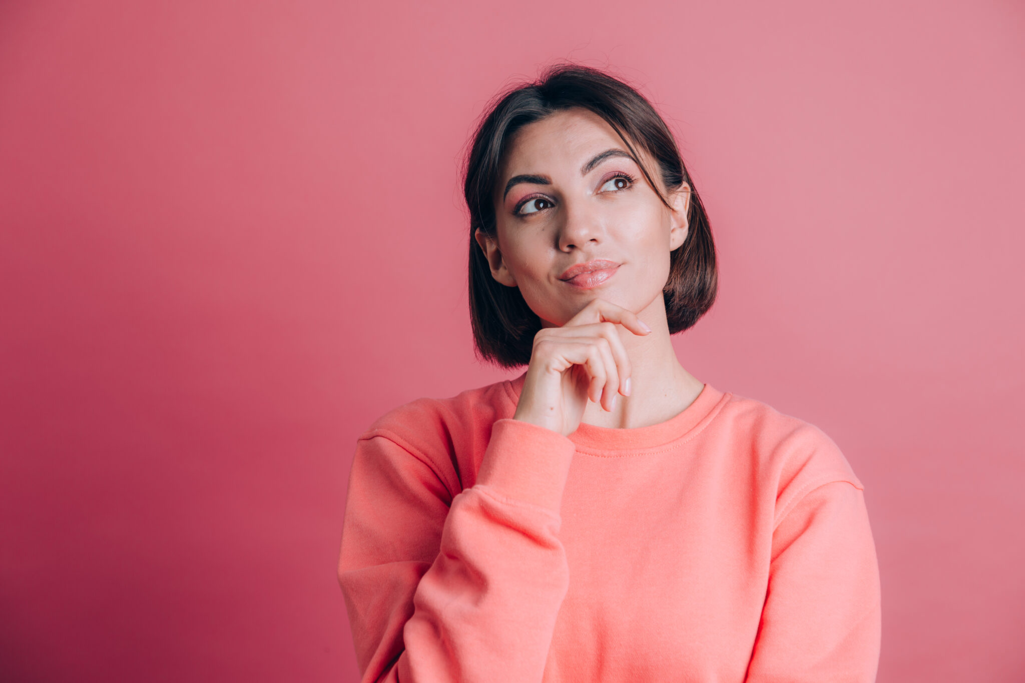 Woman wearing casual sweater on background hand on chin thinking about question, pensive expression. Smiling with thoughtful face