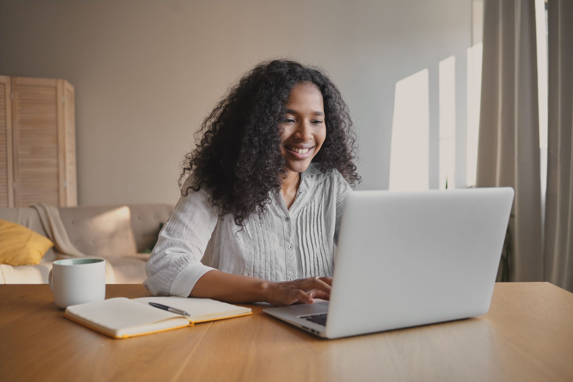 redator-alegre-jovem-afro-americano-sentado-em-frente-ao-laptop-aberto-com-caneca-e-o-caderno-na-mesa-sentindo-se-inspirado-trabalhando-em-um-novo-artigo-de-motivacao-pessoas-ocupacao-e-criatividade2